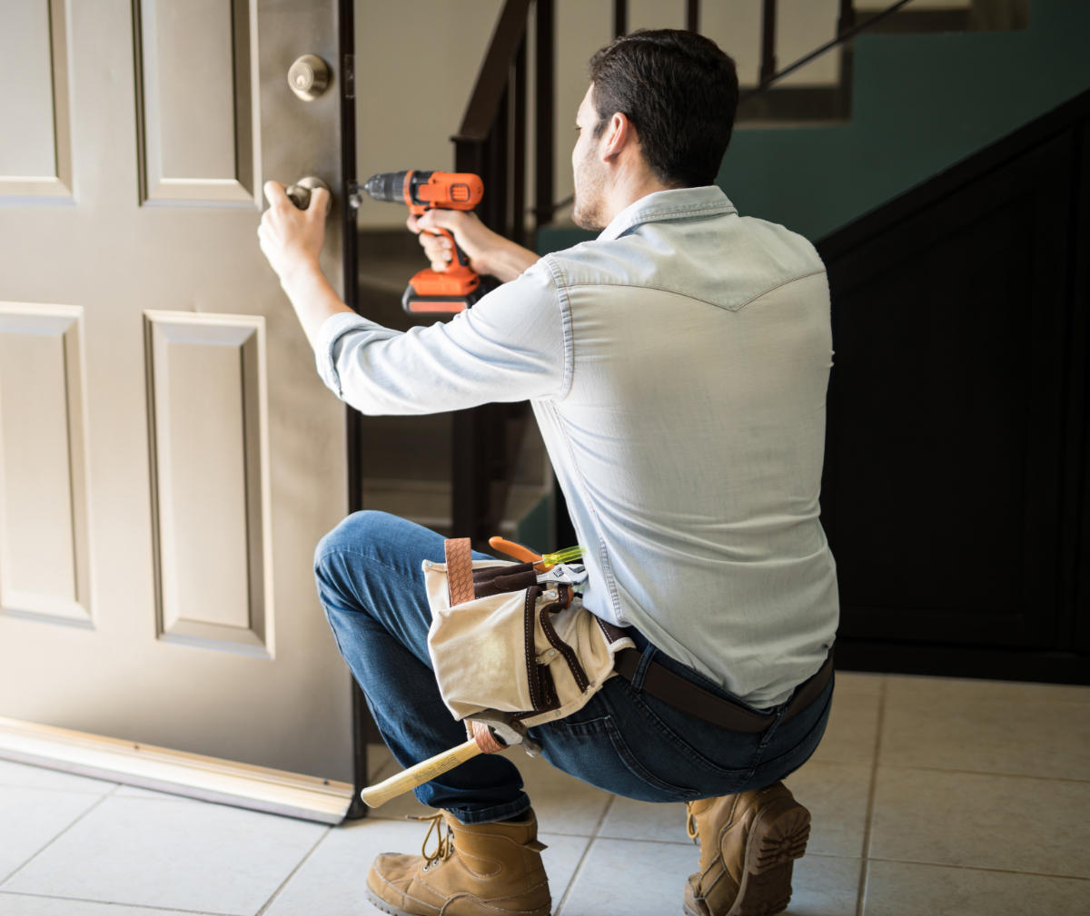 Locksmith fitting a residential door lock for a house entrance